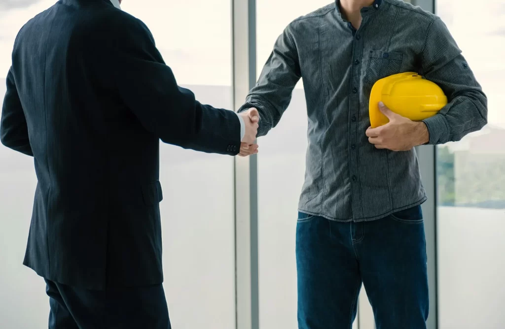 Engineer contractor team handshake after meeting work safety plan industry project